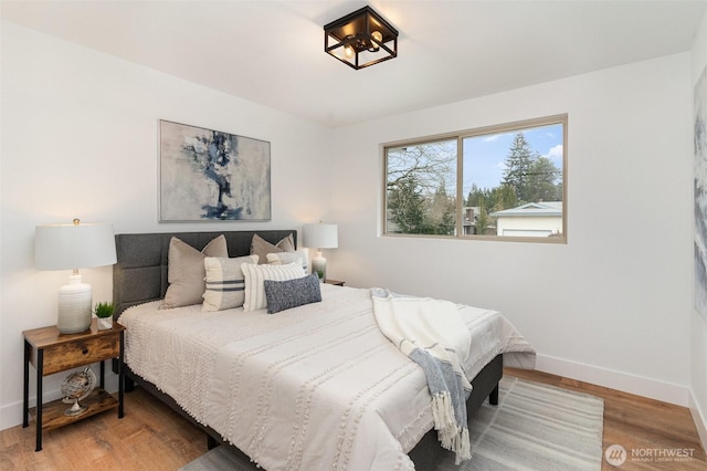 bedroom with baseboards and wood finished floors