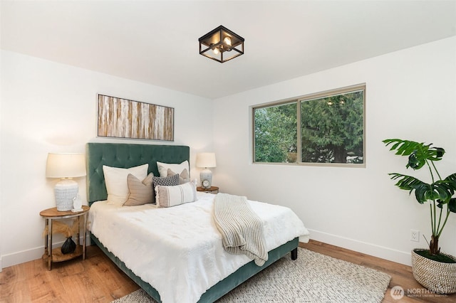 bedroom featuring wood finished floors and baseboards