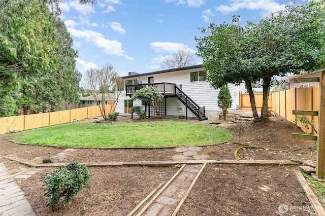 view of yard with a vegetable garden, a fenced backyard, stairway, and a wooden deck