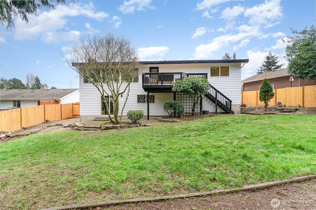 back of house featuring a fenced backyard, a yard, a wooden deck, and stairs