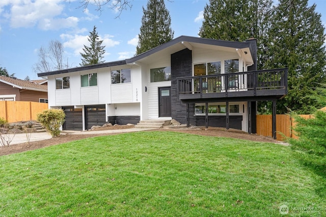 view of front of house featuring driveway, an attached garage, fence, and a front lawn