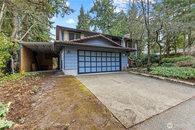 view of front of home with aphalt driveway, a tiled roof, and a garage