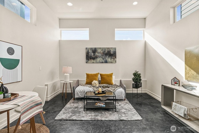 interior space with a towering ceiling, baseboards, and recessed lighting