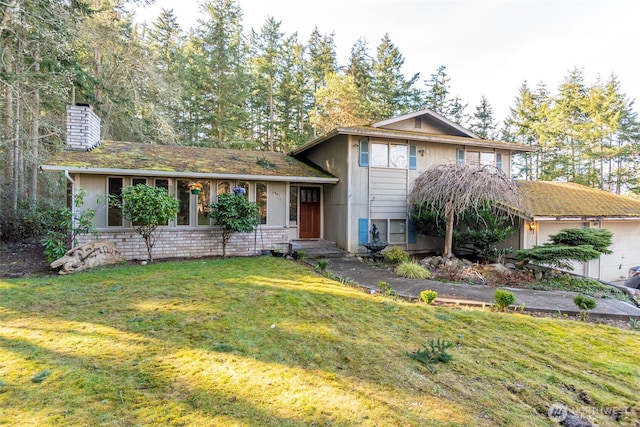 tri-level home with a garage, a front lawn, and a chimney