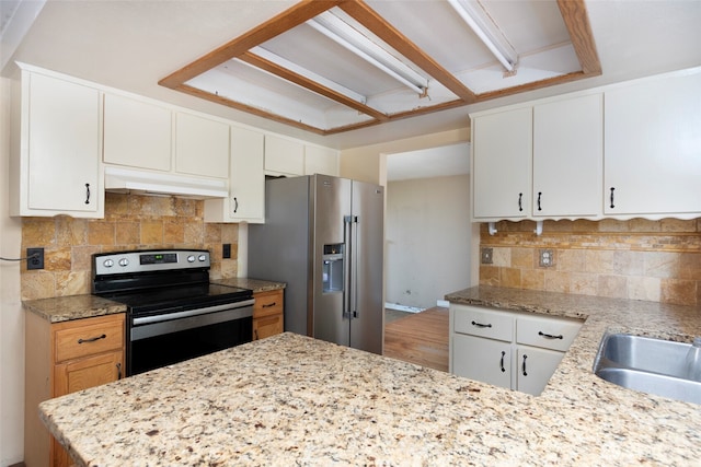 kitchen with tasteful backsplash, appliances with stainless steel finishes, white cabinetry, and under cabinet range hood