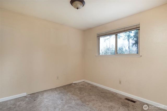 spare room featuring carpet flooring, visible vents, and baseboards