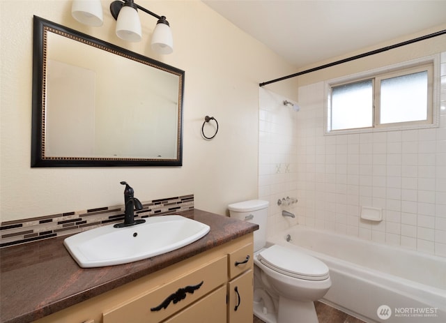 full bathroom featuring washtub / shower combination, toilet, vanity, and decorative backsplash