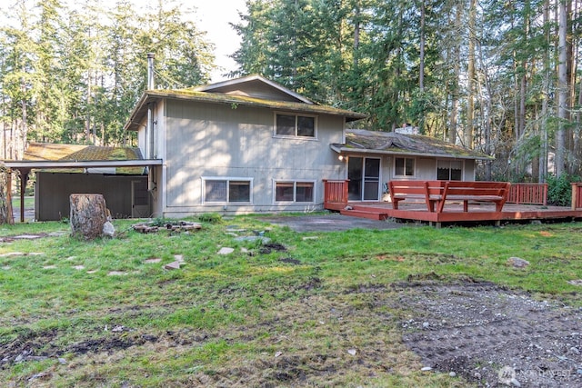 rear view of house featuring a deck and a yard