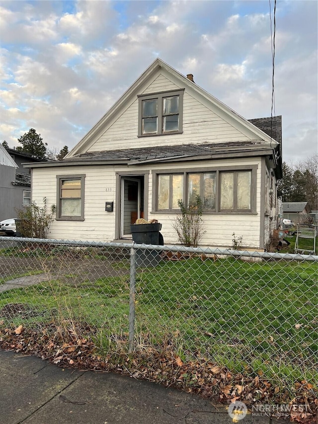 bungalow-style home with a fenced front yard and a front yard