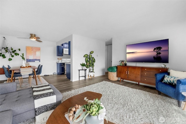 living room with dark wood finished floors and a ceiling fan