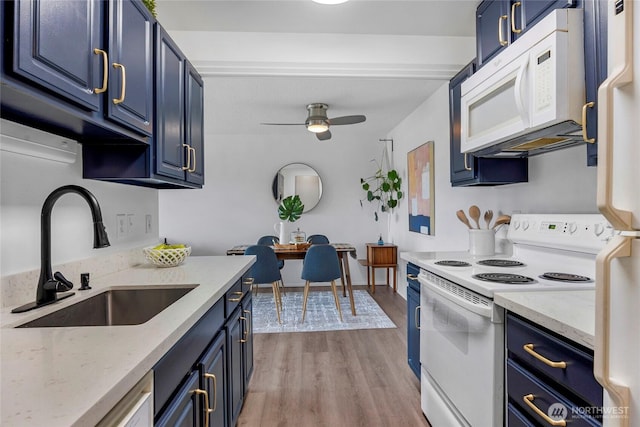 kitchen with white appliances, blue cabinets, and a sink