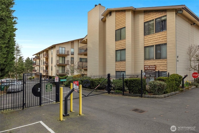 view of property featuring fence and uncovered parking