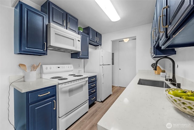 kitchen featuring blue cabinetry, white appliances, light countertops, and a sink