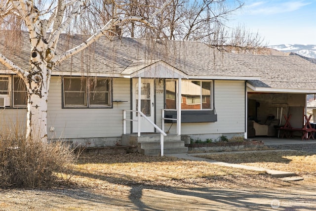 bungalow-style home with a shingled roof