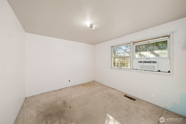 empty room with carpet, visible vents, and cooling unit