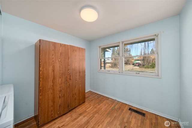 unfurnished bedroom with light wood-style flooring, a closet, visible vents, and baseboards