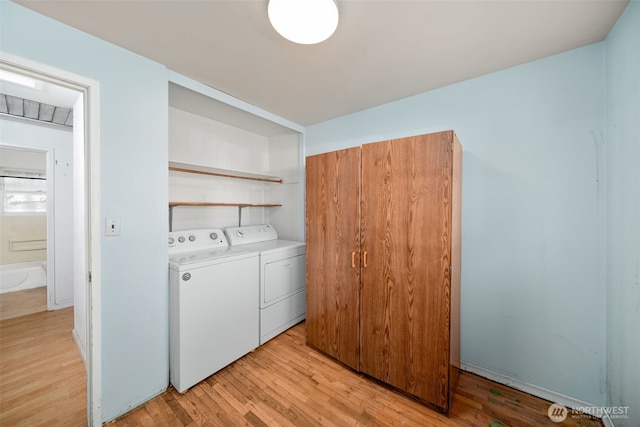 laundry room featuring laundry area, light wood-style flooring, and washer and dryer