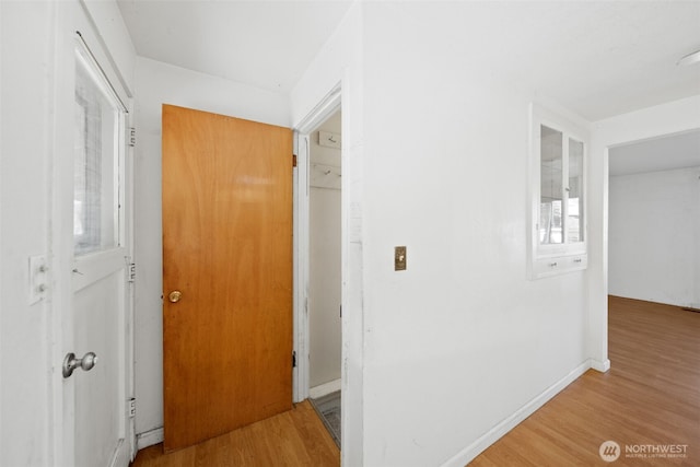 hall with baseboards and wood finished floors