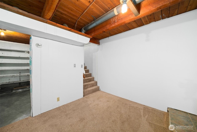 finished basement with stairway, carpet flooring, and wood ceiling