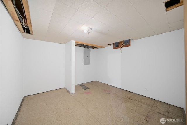 finished basement featuring electric panel and tile patterned floors