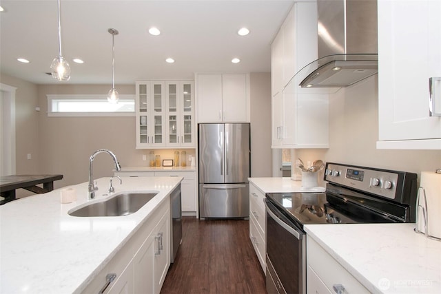 kitchen featuring wall chimney exhaust hood, glass insert cabinets, appliances with stainless steel finishes, white cabinetry, and a sink