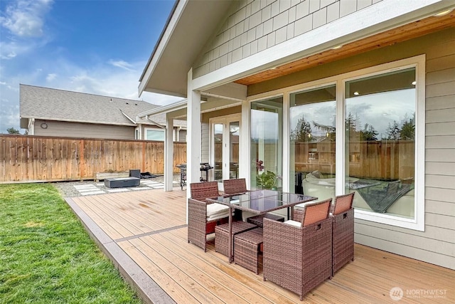 wooden deck featuring fence, outdoor dining area, a lawn, and french doors