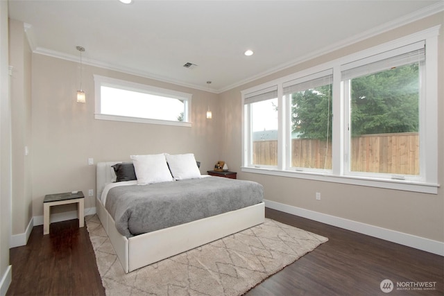 bedroom featuring baseboards, wood finished floors, visible vents, and crown molding