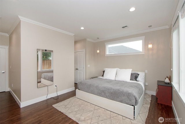 bedroom featuring baseboards, visible vents, wood finished floors, and ornamental molding