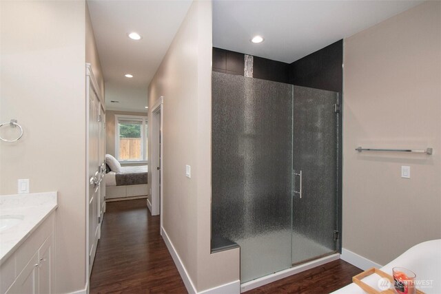 ensuite bathroom with a stall shower, recessed lighting, wood finished floors, and ensuite bathroom