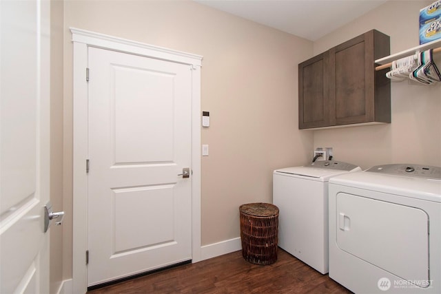 laundry area featuring dark wood-type flooring, washer and dryer, cabinet space, and baseboards