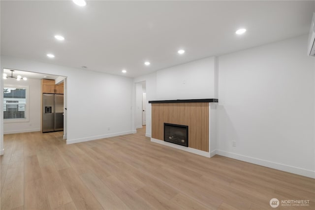 unfurnished living room with a fireplace, recessed lighting, and light wood-style floors