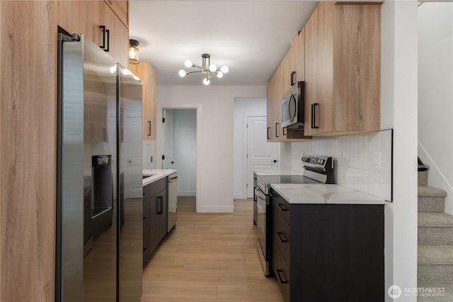 kitchen with light countertops, tasteful backsplash, a chandelier, and stainless steel appliances