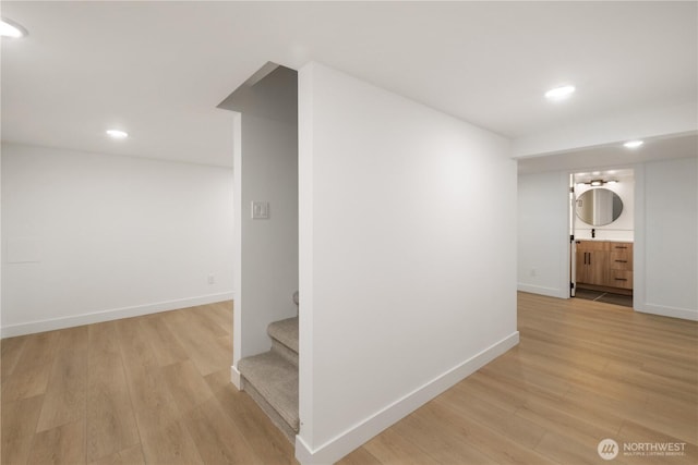 hallway with recessed lighting, light wood-type flooring, and baseboards