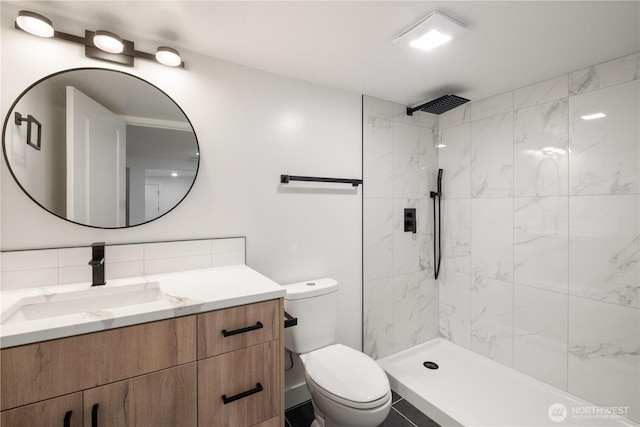 full bath with vanity, decorative backsplash, toilet, and tiled shower