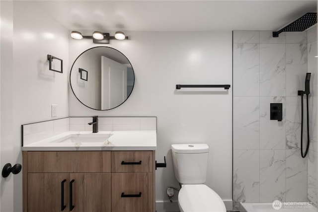 bathroom featuring a marble finish shower, toilet, and vanity