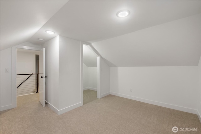 bonus room with baseboards and light carpet