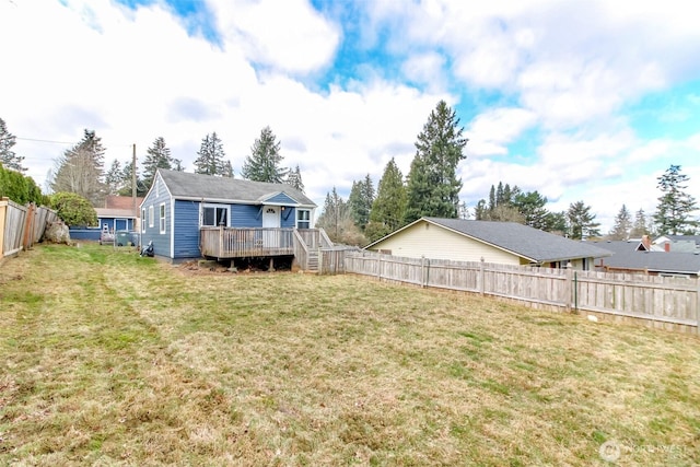 back of property featuring a fenced backyard, a lawn, and a wooden deck