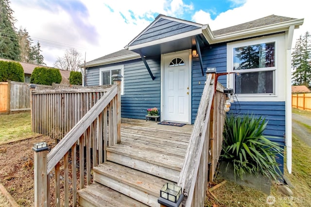 doorway to property with fence and a deck