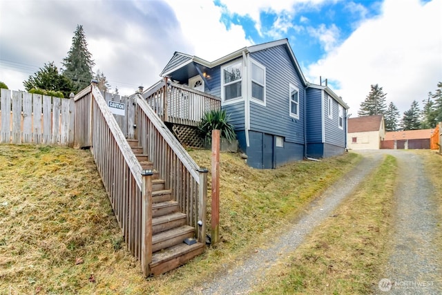 exterior space featuring stairs, fence, and a wooden deck