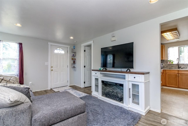 living area with light wood finished floors, baseboards, and recessed lighting