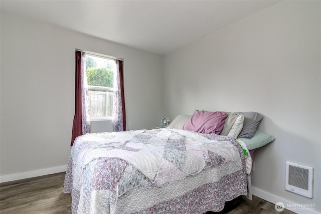 bedroom with dark wood-style flooring, visible vents, and baseboards