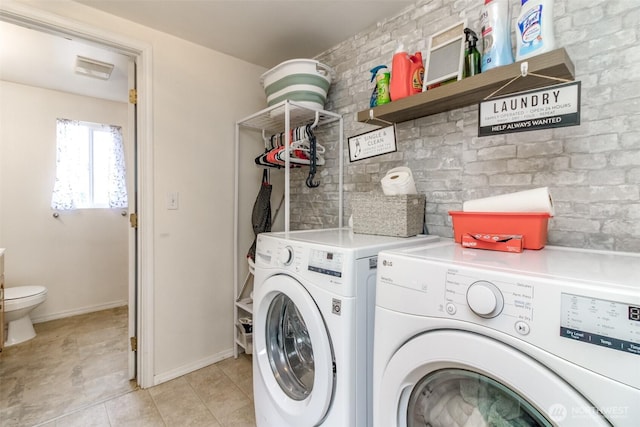 laundry area with washer and dryer, laundry area, baseboards, and light tile patterned floors