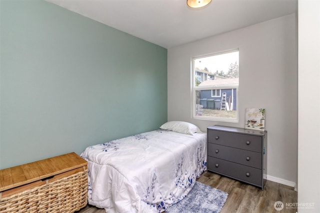 bedroom featuring baseboards and wood finished floors