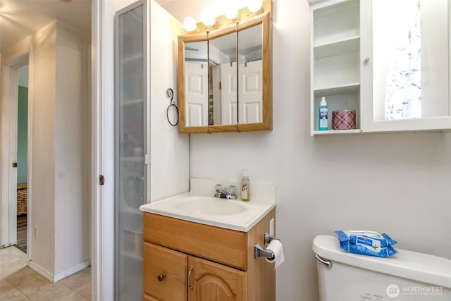 bathroom with toilet, tile patterned floors, and vanity