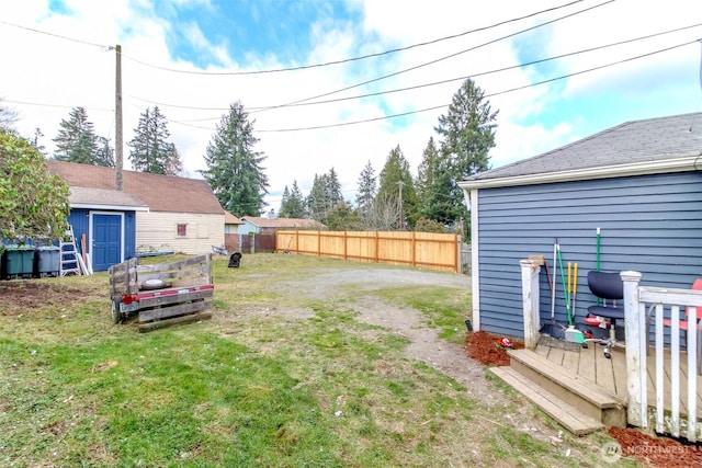 view of yard with an outdoor structure, a storage shed, and fence