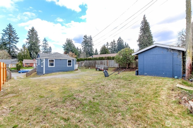 view of yard with a fenced backyard and an outbuilding