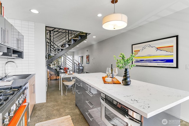 kitchen with tasteful backsplash, a kitchen island, a sink, and recessed lighting