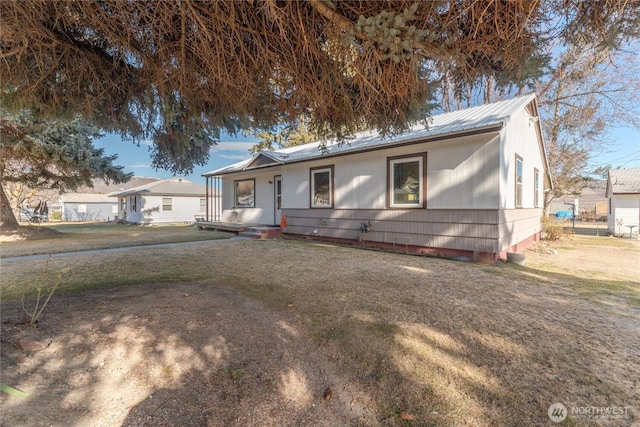 view of front of home featuring a front lawn and metal roof