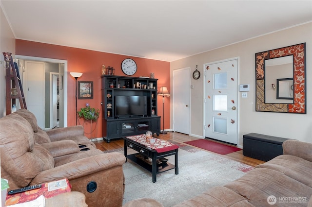 living area with baseboards and wood finished floors