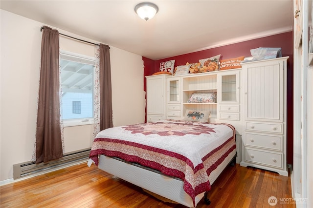 bedroom with hardwood / wood-style flooring and a baseboard radiator